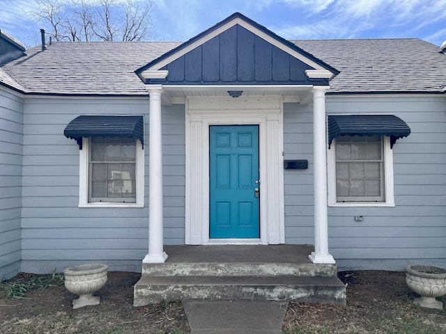 property entrance with a shingled roof and board and batten siding