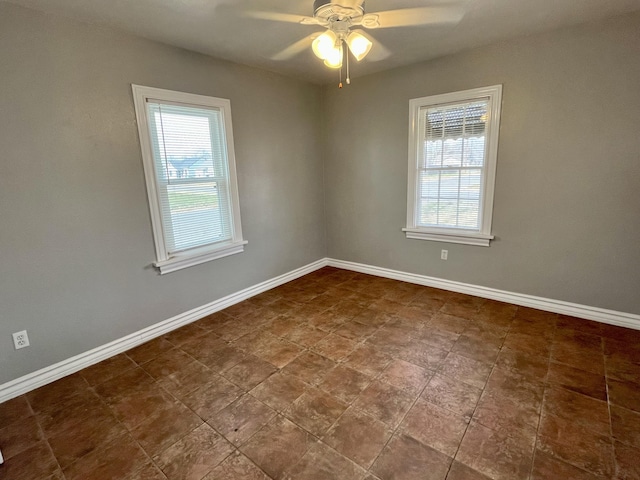 spare room featuring baseboards and a ceiling fan