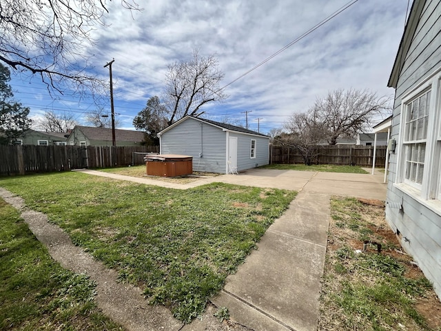 view of yard featuring a patio area, a fenced backyard, an outdoor structure, and a hot tub