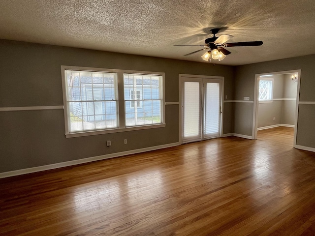 empty room with plenty of natural light and wood finished floors