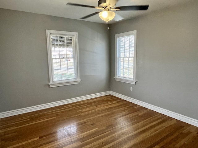 unfurnished room with ceiling fan, baseboards, and dark wood finished floors