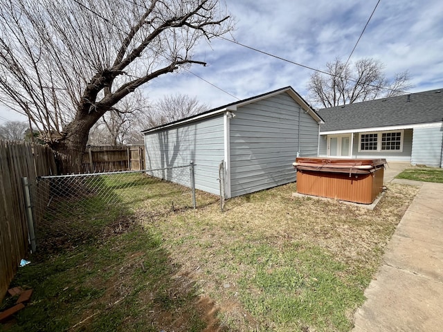 exterior space with a fenced backyard and a hot tub