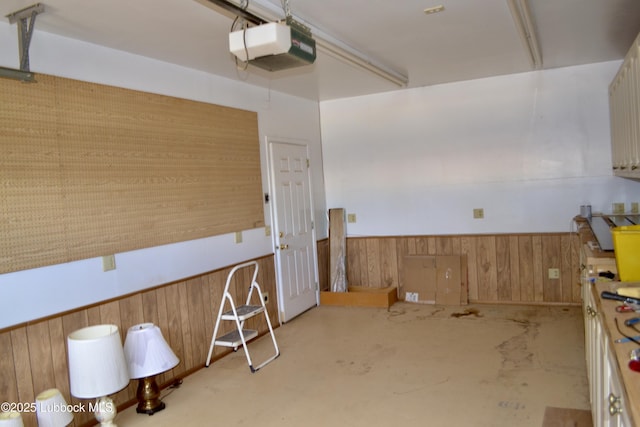 200 Crescent Dr, Littlefield, TX 79339 - interior space featuring wood walls, a wainscoted wall, and a garage door opener
