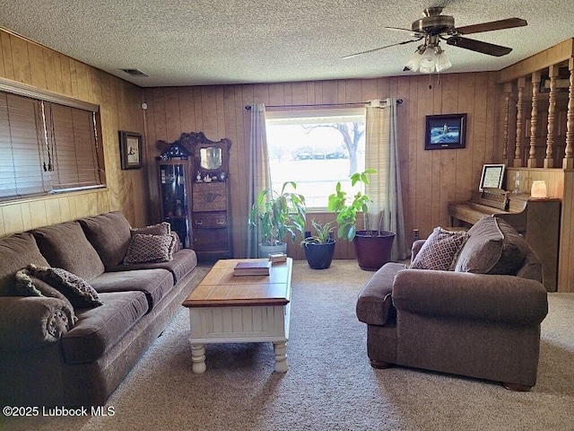 200 Crescent Dr, Littlefield, TX 79339 - living area with carpet, a textured ceiling, wood walls, and a ceiling fan