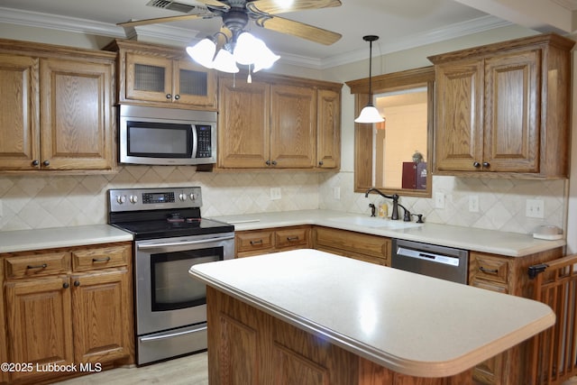 200 Crescent Dr, Littlefield, TX 79339 - kitchen with stainless steel appliances, brown cabinets, ceiling fan, and a sink