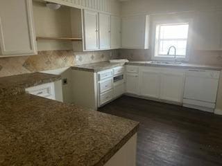 kitchen with dishwasher, white cabinetry, sink, and kitchen peninsula