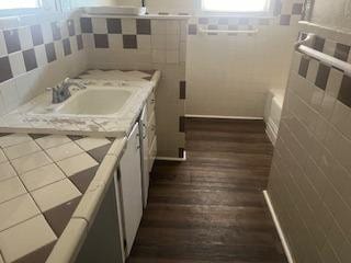 bathroom with vanity and tile walls