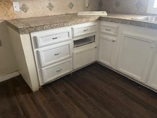 kitchen with dark wood-type flooring, sink, and white cabinets