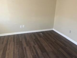 empty room featuring dark wood-type flooring