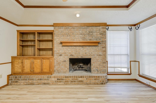 unfurnished living room featuring crown molding, a fireplace, a textured ceiling, and light wood-type flooring