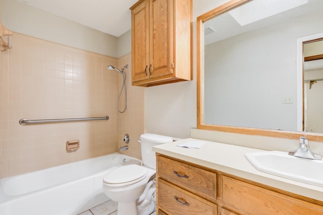 full bathroom with tiled shower / bath, vanity, tile patterned floors, and toilet