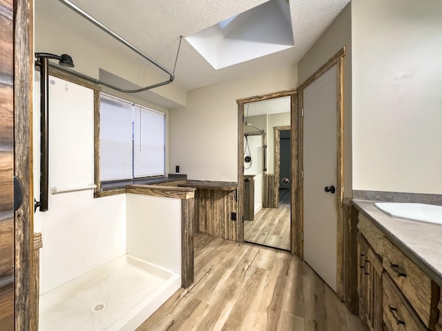 bathroom with vanity, a shower, hardwood / wood-style floors, and a textured ceiling