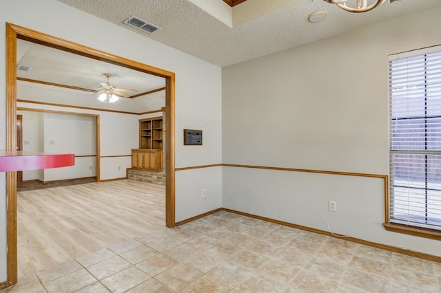 empty room featuring ceiling fan, a textured ceiling, and light wood-type flooring