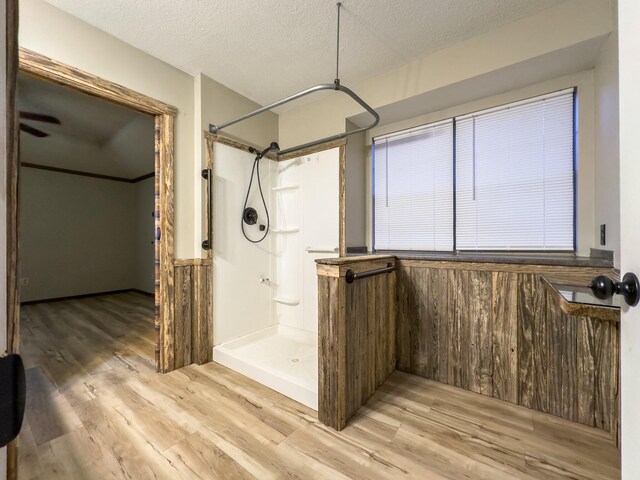 bathroom with a shower, hardwood / wood-style floors, and a textured ceiling