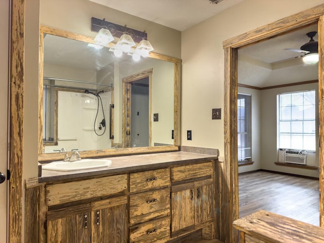 bathroom featuring a shower, cooling unit, vanity, hardwood / wood-style flooring, and ceiling fan