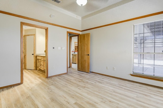 unfurnished bedroom with vaulted ceiling, sink, a textured ceiling, and light wood-type flooring