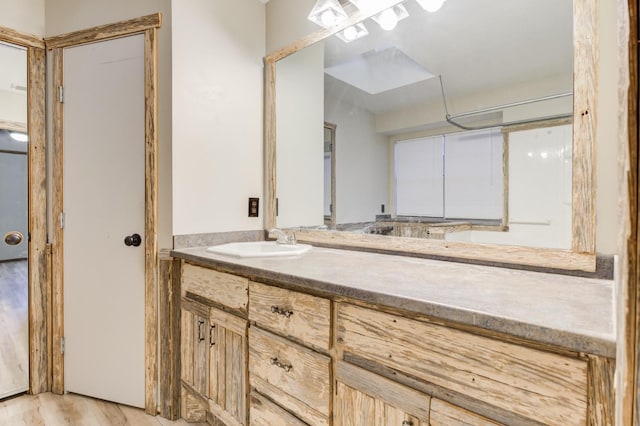 bathroom featuring vanity, wood-type flooring, and walk in shower