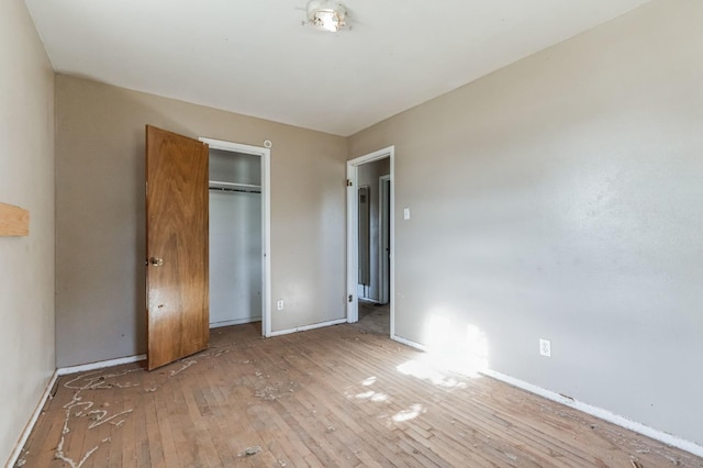 unfurnished bedroom with light wood-type flooring and a closet