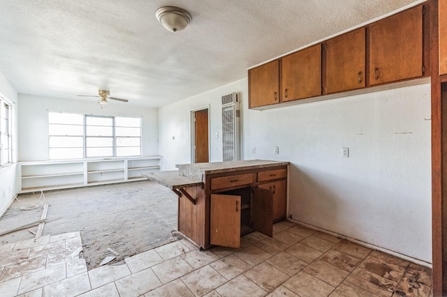 kitchen featuring plenty of natural light, a textured ceiling, and a kitchen bar