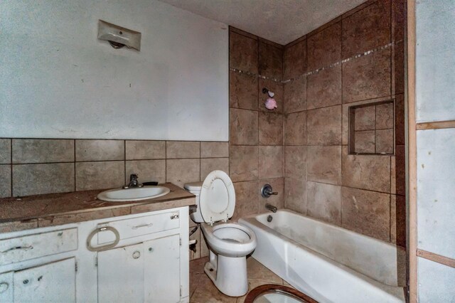 bathroom with vanity, tile walls, tile patterned floors, and toilet