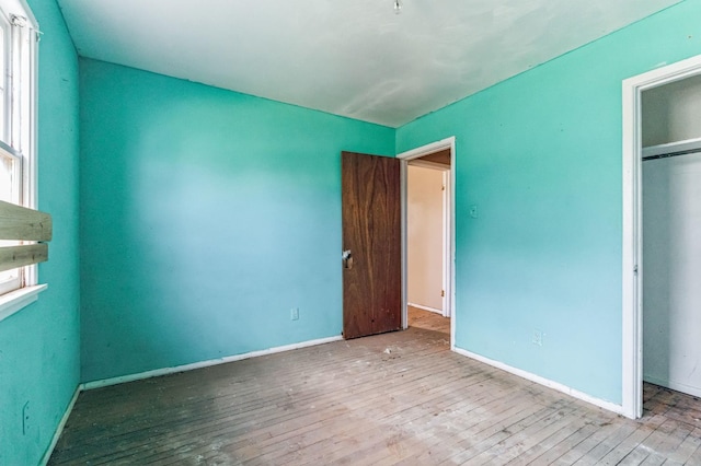 unfurnished bedroom with light hardwood / wood-style floors and a closet