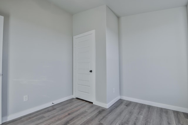 empty room featuring wood finished floors and baseboards