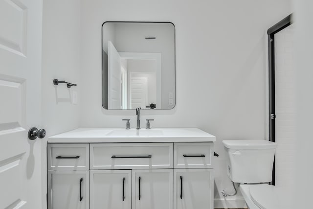 bathroom with visible vents, toilet, and vanity