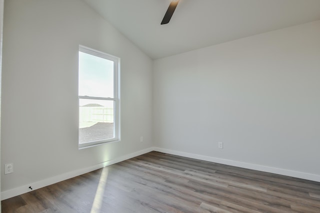 empty room with dark wood-style floors, ceiling fan, lofted ceiling, and baseboards