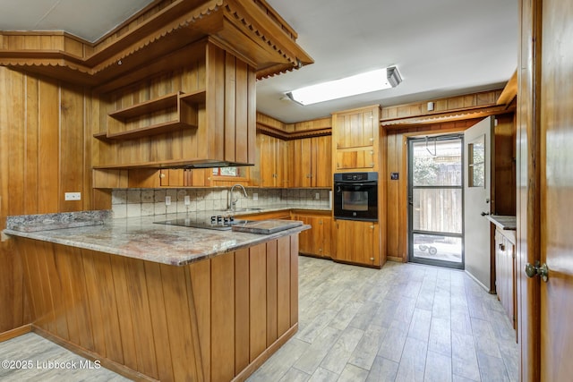 3413 42nd St, Lubbock, TX 79413 - kitchen featuring oven, brown cabinets, decorative backsplash, a peninsula, and light wood finished floors