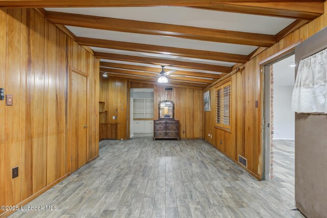 3413 42nd St, Lubbock, TX 79413 - empty room with beam ceiling, wood walls, wood finished floors, and a ceiling fan