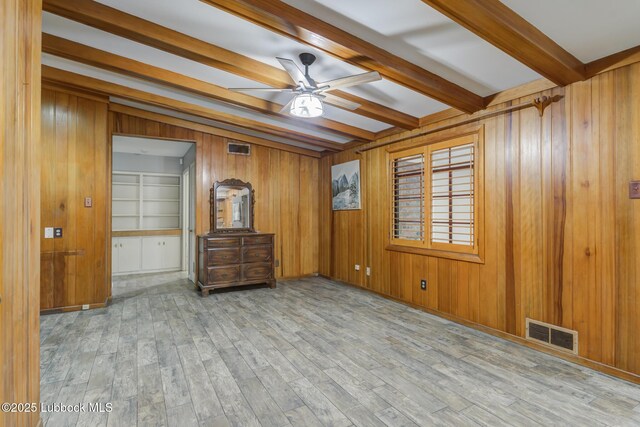 3413 42nd St, Lubbock, TX 79413 - unfurnished room with beam ceiling, ceiling fan, wooden walls, and wood finished floors