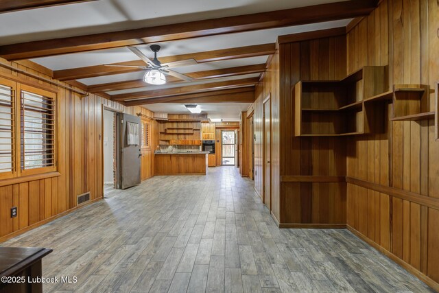 3413 42nd St, Lubbock, TX 79413 - kitchen with brown cabinets, wooden walls, a ceiling fan, light wood finished floors, and open shelves