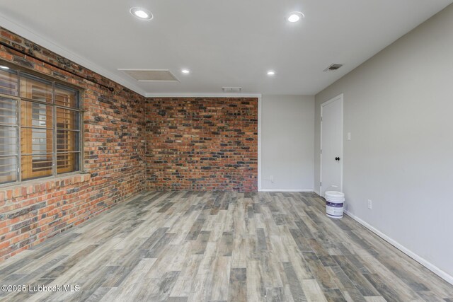 3413 42nd St, Lubbock, TX 79413 - empty room featuring brick wall, wood finished floors, recessed lighting, attic access, and baseboards
