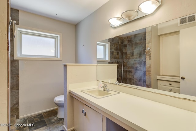 3413 42nd St, Lubbock, TX 79413 - full bath featuring toilet, vanity, stone finish flooring, and tiled shower