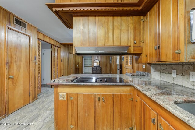 3413 42nd St, Lubbock, TX 79413 - kitchen featuring black electric cooktop, brown cabinetry, a peninsula, and light wood finished floors
