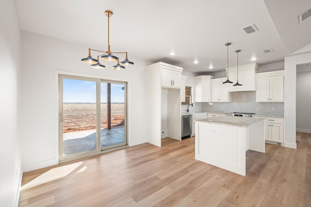 kitchen featuring white cabinetry, decorative light fixtures, dishwasher, and a kitchen island