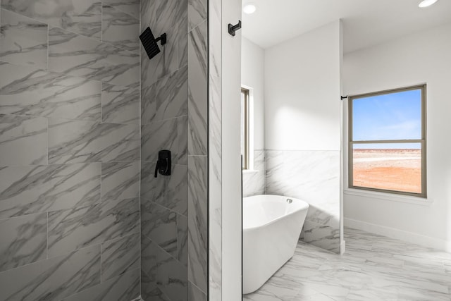 bathroom with tile walls and separate shower and tub