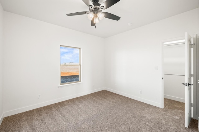 empty room with ceiling fan and carpet