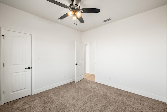 unfurnished room featuring light colored carpet and ceiling fan