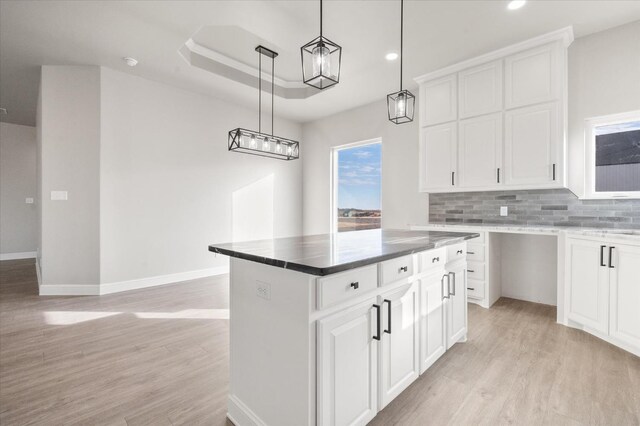 kitchen with a kitchen island, pendant lighting, and white cabinets