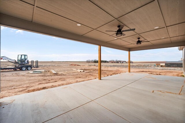 view of patio with ceiling fan and a rural view