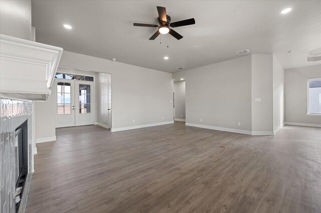 unfurnished living room with dark hardwood / wood-style floors, french doors, and ceiling fan