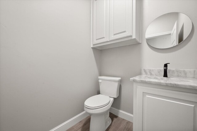 bathroom with vanity, toilet, and wood-type flooring