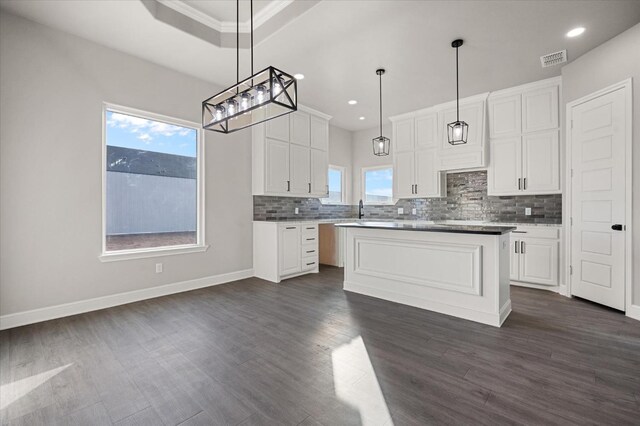 kitchen featuring pendant lighting, plenty of natural light, white cabinets, and a kitchen island