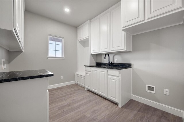 kitchen featuring sink, white cabinets, and light wood-type flooring