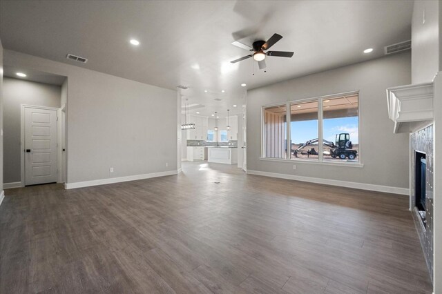 unfurnished living room with ceiling fan and dark hardwood / wood-style flooring