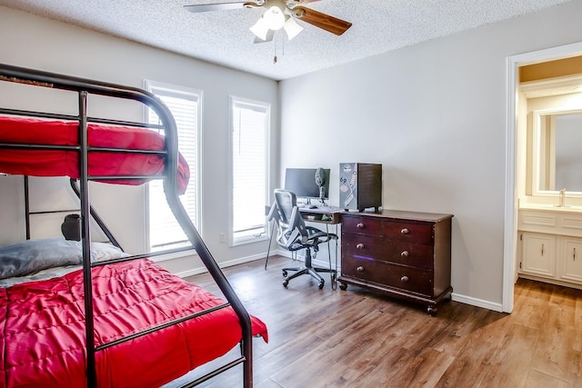 bedroom featuring ceiling fan, sink, a textured ceiling, and light hardwood / wood-style flooring