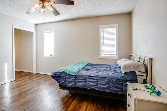 bedroom featuring ceiling fan, dark hardwood / wood-style flooring, and a textured ceiling