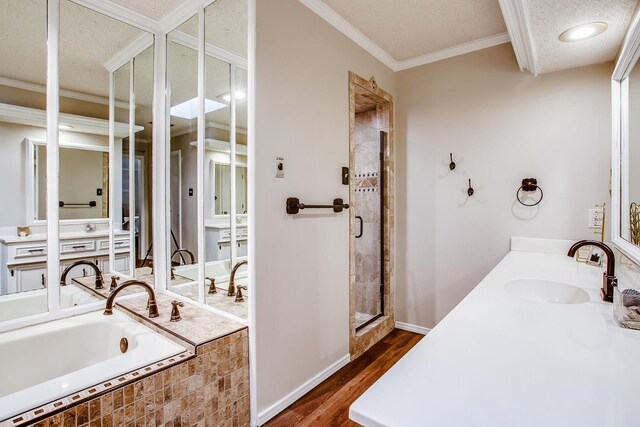 bathroom featuring vanity, hardwood / wood-style flooring, ornamental molding, and shower with separate bathtub