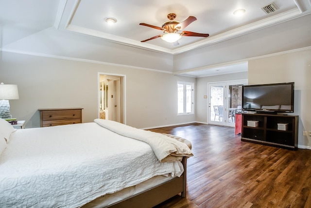 bedroom with crown molding, a tray ceiling, access to exterior, and dark wood-type flooring